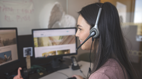 Person som talar i telefon med hörlurar