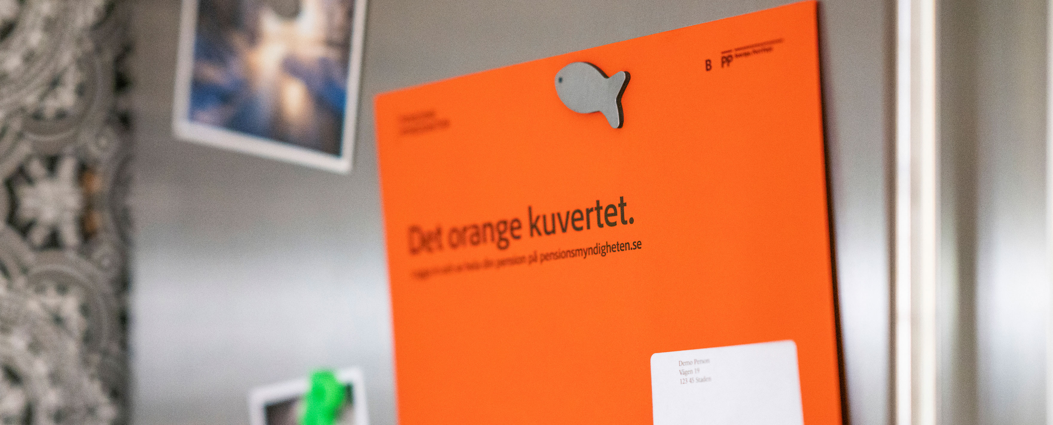 Orange kuvert om pension på kylskåp